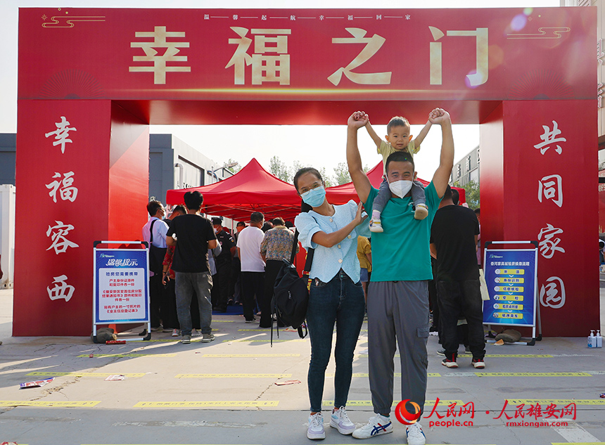 回遷群眾一家三口在“幸福之門”前合影。齊鑫攝