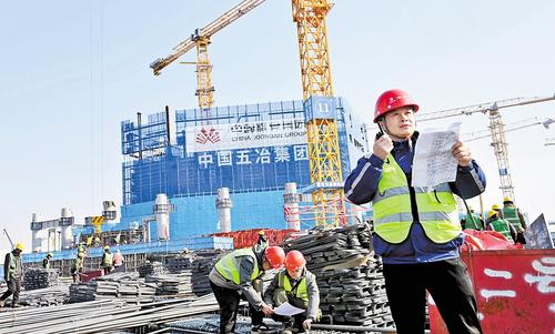 1月20日，雄安城際站及國貿中心項目建設現場，中國五冶集團雄安國貿中心項目常務副指揮長黃紹平(右一）正在進行巡查。本報記者 劉光昱攝