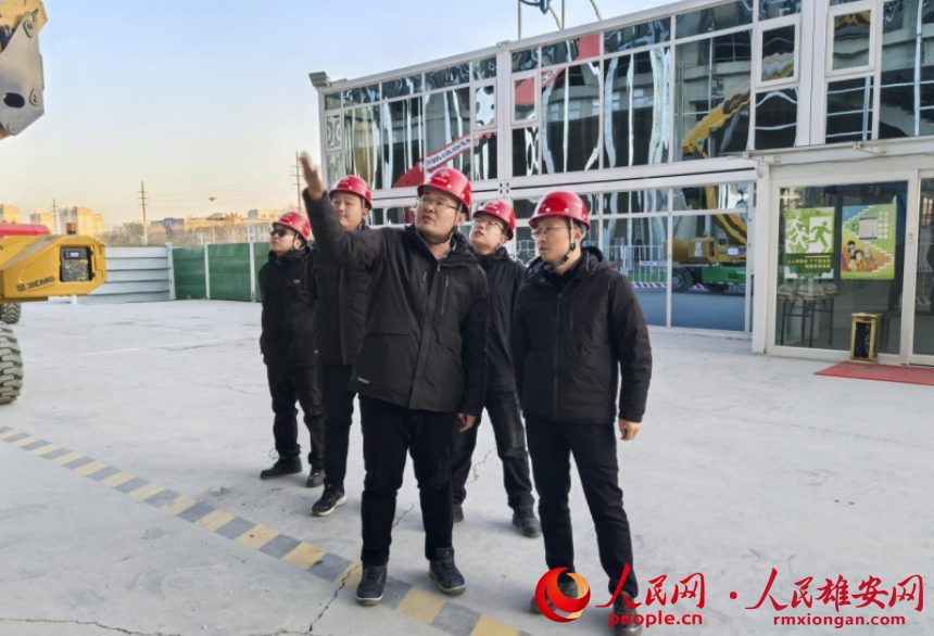 朱懷宇（右一）在雄州站施工現場。人民網記者 唐心怡攝