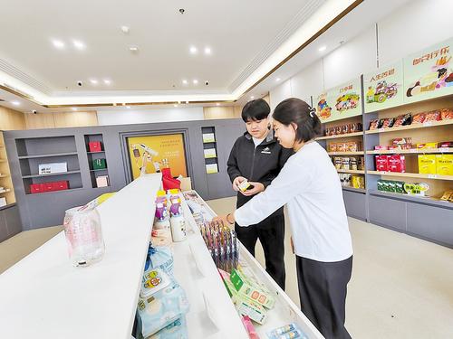 10月11日，雄安保稅商品直購體驗店工作人員（左）向消費者介紹保稅商品。 本報見習記者 康曉博攝